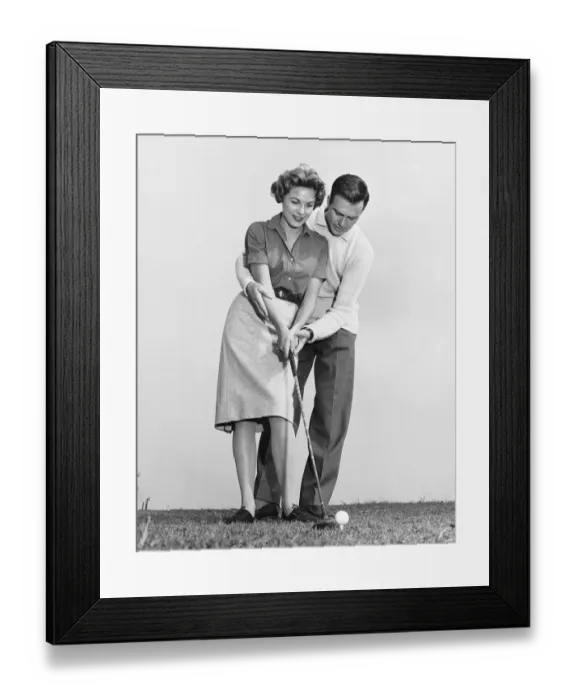 Framed Print : Man teaching woman how to hit golfball Framed Print : Man teaching woman how to hit golfball