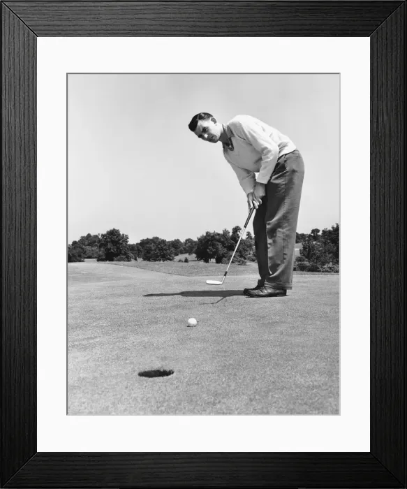 Framed Print : Man watching golf ball after hitting it with putter Framed Print : Man watching golf ball after hitting it with putter