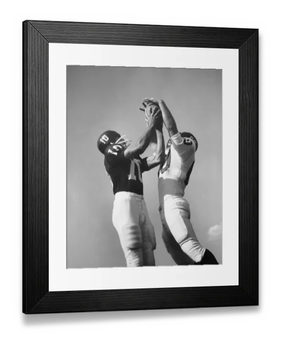 Framed Print : Two football players jumping for ball at same time Framed Print : Two football players jumping for ball at same time