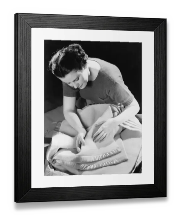 Framed Print : Woman inspecting woollen blanket, (B&W) Framed Print : Woman inspecting woollen blanket, (B&W)