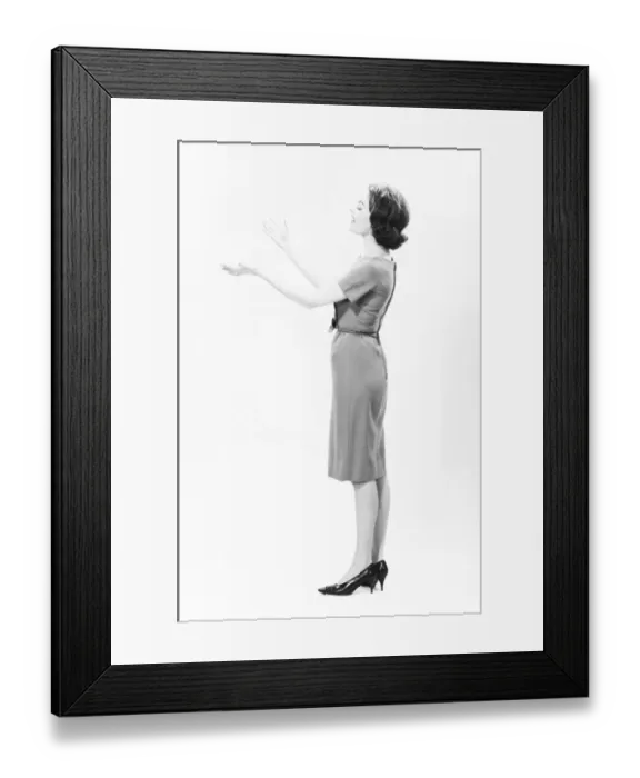 Framed Print : Elegant woman standing in studio, gesturing, (B&W) Framed Print : Elegant woman standing in studio, gesturing, (B&W)