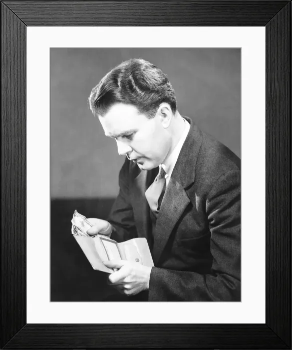 Framed Print : Man putting US dollars bills into wallet, (B&W) Framed Print : Man putting US dollars bills into wallet, (B&W)