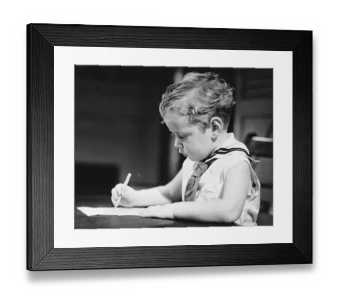 Framed Print : Boy (4-5) wearing sailor suit drawing at table, (B&W) Framed Print : Boy (4-5) wearing sailor suit drawing at table, (B&W)