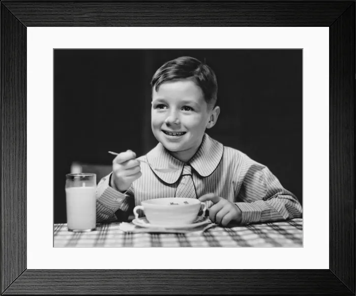 Framed Print : Elegant boy (6-7) eating at table, (B&W), portrait Framed Print : Elegant boy (6-7) eating at table, (B&W), portrait