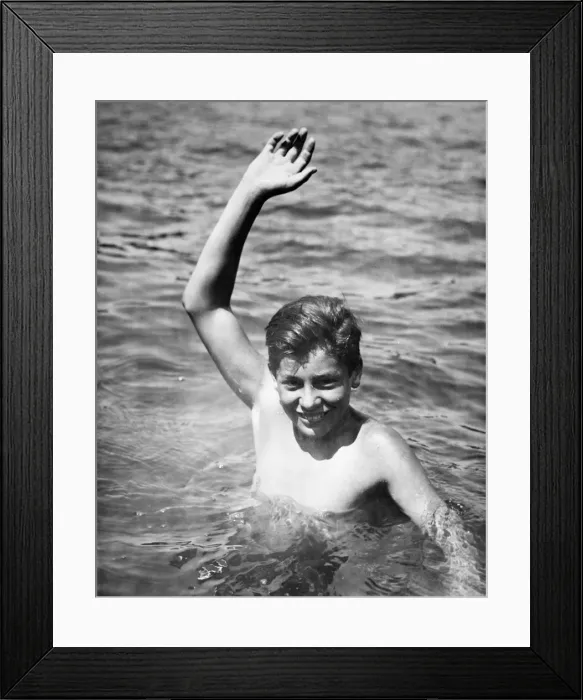 Framed Print : Teenage boy (16-17) standing deep in water, waving, (B&W), portrait Framed Print : Teenage boy (16-17) standing deep in water, waving, (B&W), portrait