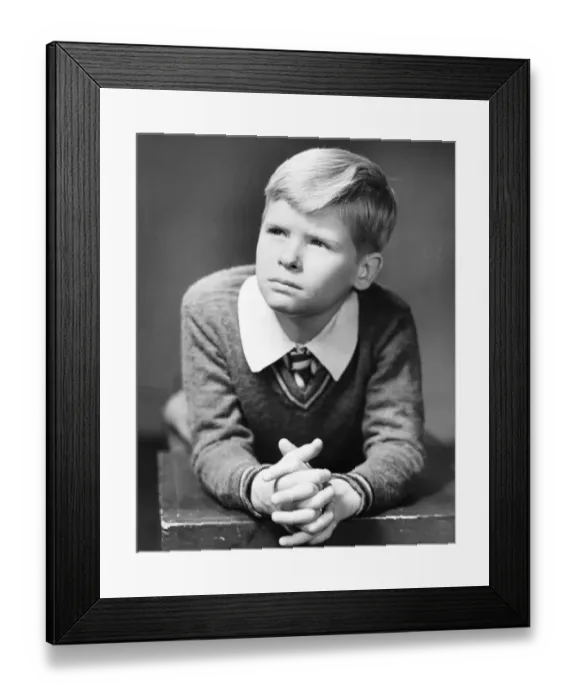Framed Print : Boy (6-7) bending forward, resting hands on wooden box, (B&W), close-up Framed Print : Boy (6-7) bending forward, resting hands on wooden box, (B&W), close-up