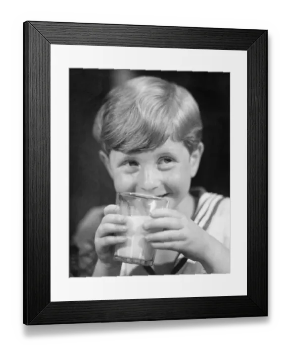 Framed Print : Boy (8-9) drinking milk from glass, smiling, (B&W) Framed Print : Boy (8-9) drinking milk from glass, smiling, (B&W)