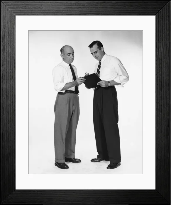 Framed Print : Two men standing, looking at clipboard Framed Print : Two men standing, looking at clipboard