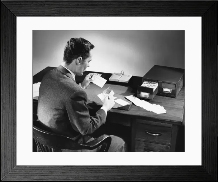 Framed Print : Back view of man sitting and looking at address cards Framed Print : Back view of man sitting and looking at address cards
