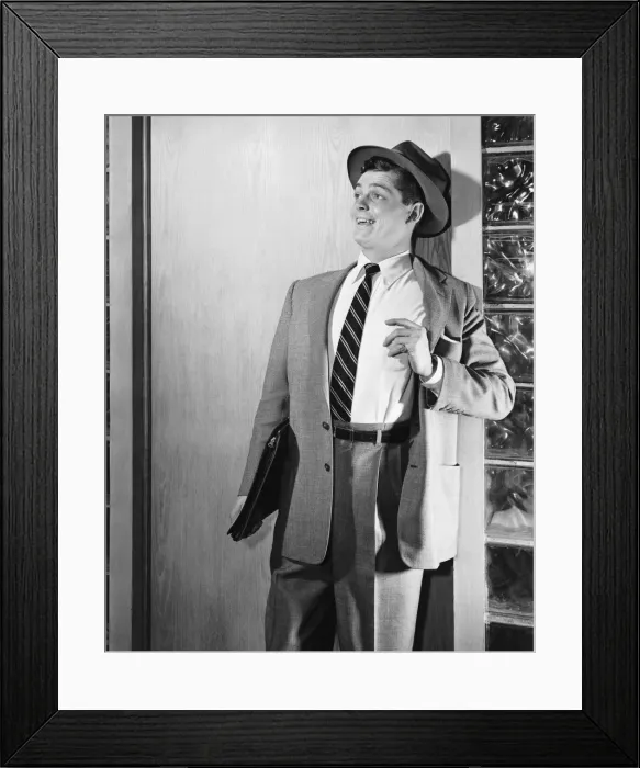 Framed Print : Man leaning against door, smiling Framed Print : Man leaning against door, smiling