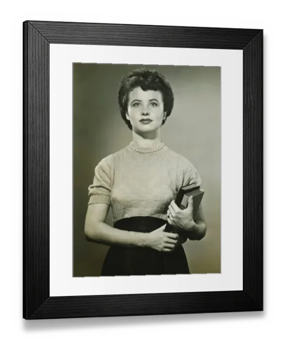 Framed Print : Woman holding books, posing in studio, (Portrait), (B&W)