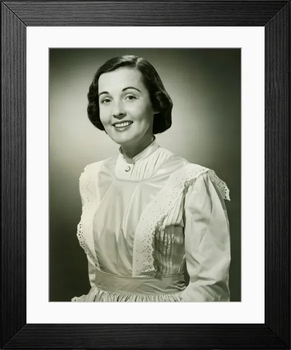 Framed Print : Woman in white apron posing in studio, (B&W), (Portrait) Framed Print : Woman in white apron posing in studio, (B&W), (Portrait)