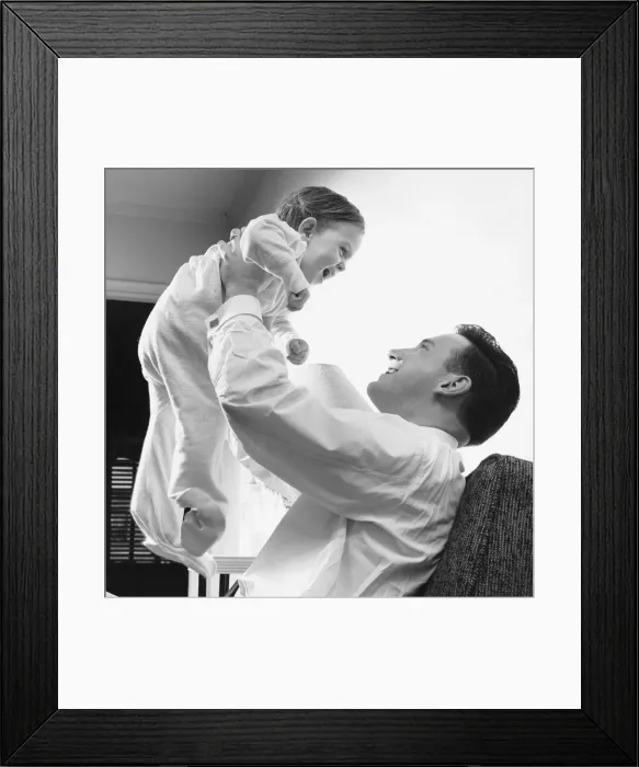 Framed Print : Man raising baby over head Framed Print : Man raising baby over head