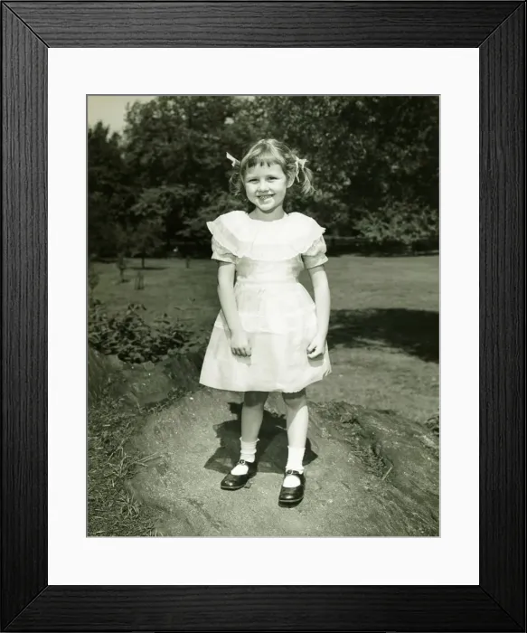 Framed Print : Girl (6-7) in white dress posing in park, (B&W), (Portrait) Framed Print : Girl (6-7) in white dress posing in park, (B&W), (Portrait)