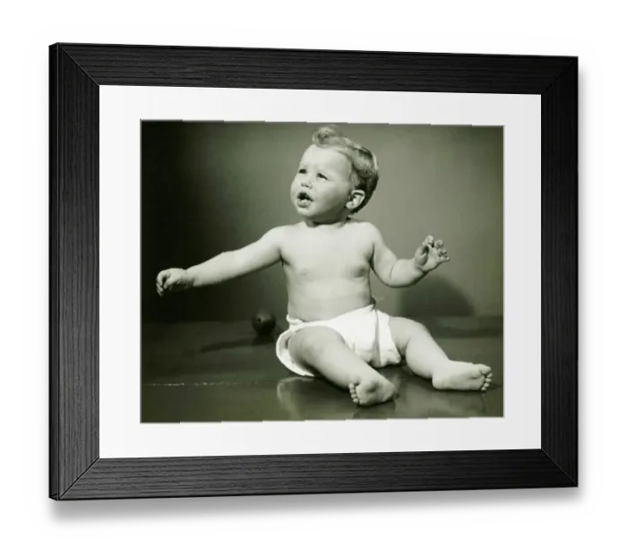 Framed Print : Baby boy (6-12) in nappy sitting on floor, (B&W)