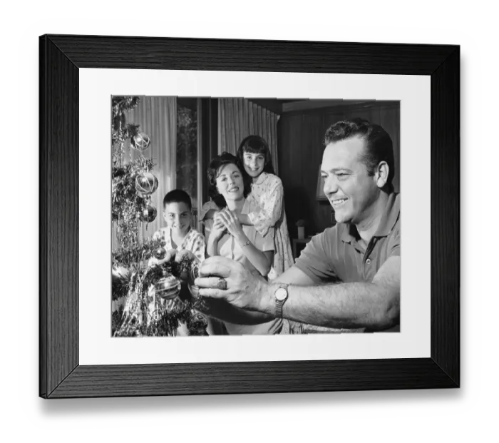 Framed Print : Family in living room, father decorating Christmas tree Framed Print : Family in living room, father decorating Christmas tree