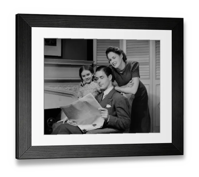 Framed Print : Parents with daughter (6-7 years) reading newspaper together