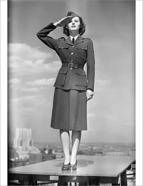 Female soldier standing on table and saluting
