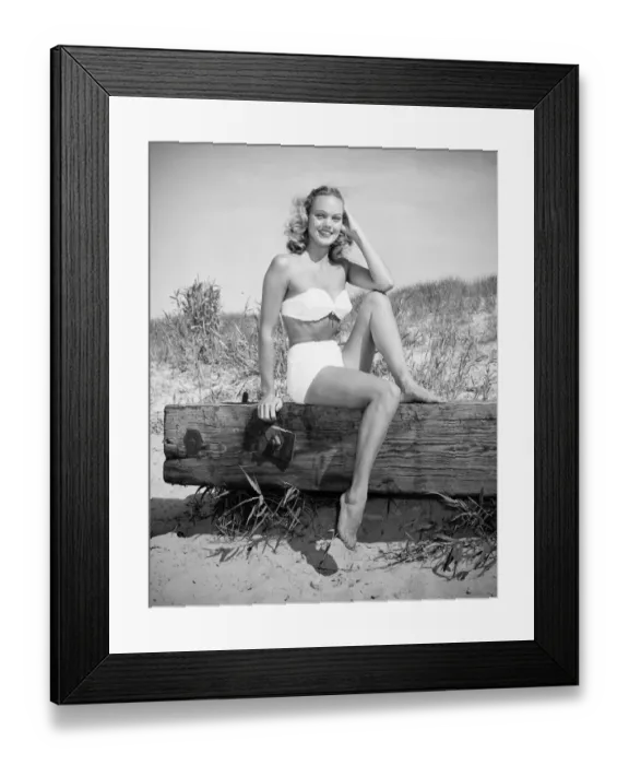 Framed Print : Woman wearing bikini sitting on log on beach, (B&W), (Portrait) Framed Print : Woman wearing bikini sitting on log on beach, (B&W), (Portrait)