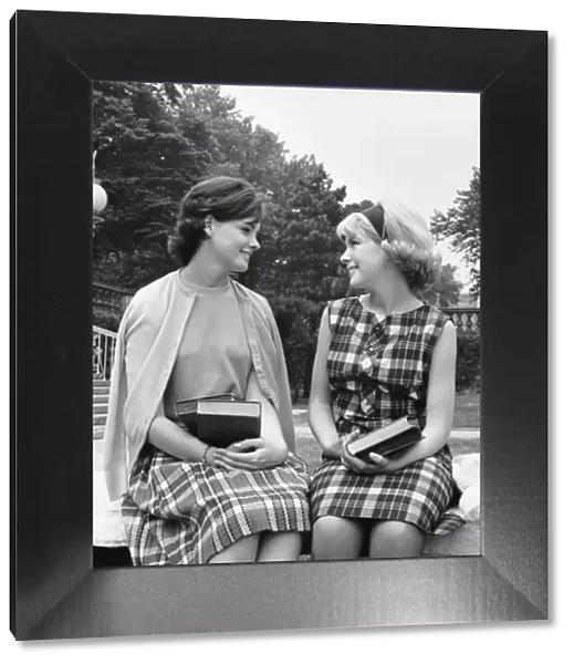 Two women sitting on school campus, talking