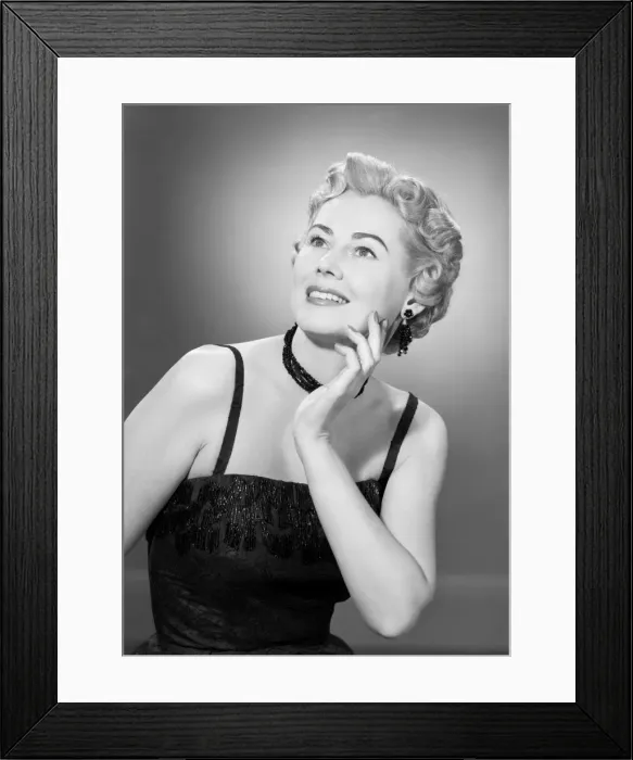 Framed Print : Studio shot of mid adult woman looking up Framed Print : Studio shot of mid adult woman looking up