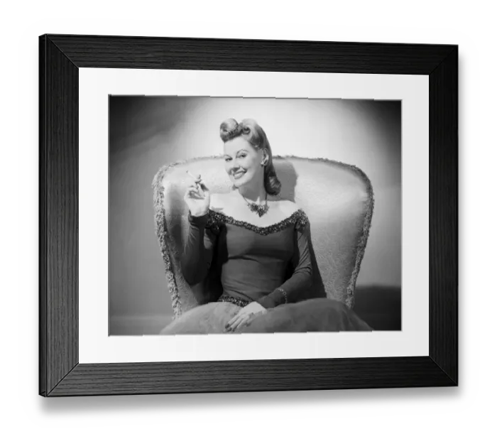 Framed Print : Portrait of mid adult woman sitting in armchair Framed Print : Portrait of mid adult woman sitting in armchair