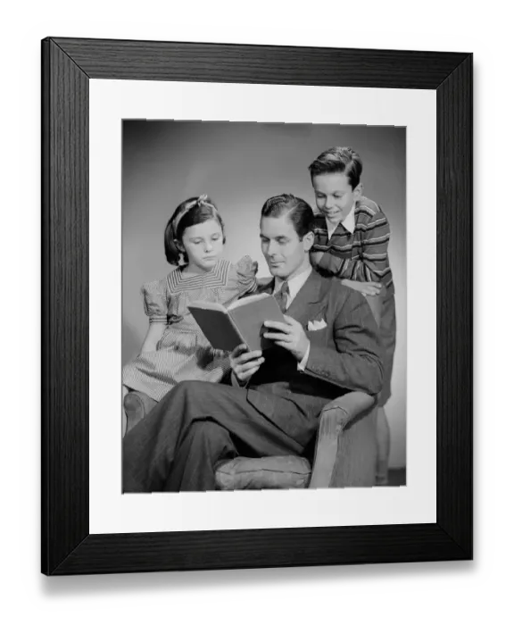 Framed Print : Studio shot of father with two children (10-11) reading book