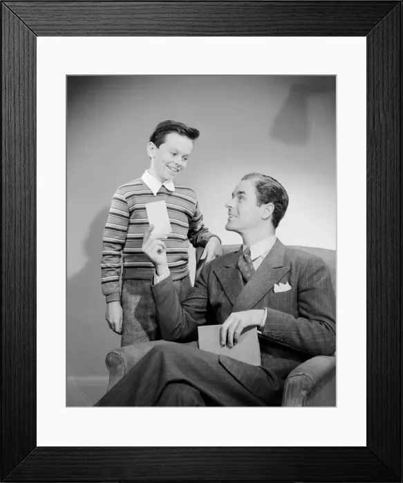 Framed Print : Father showing card to son (10-11 years)