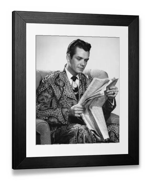 Framed Print : Man sitting in armchair, reading newspaper Framed Print : Man sitting in armchair, reading newspaper