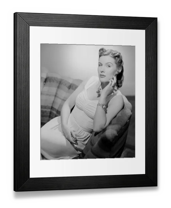 Framed Print : Portrait of mid adult woman sitting on sofa Framed Print : Portrait of mid adult woman sitting on sofa