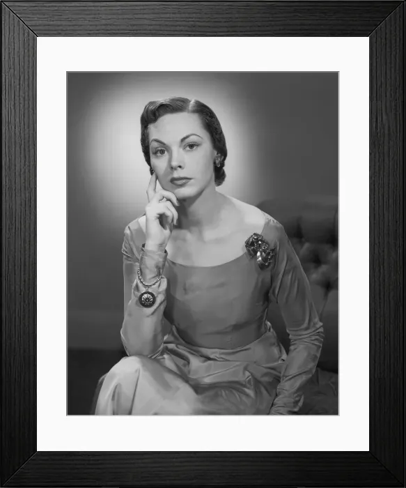 Framed Print : Young woman sitting on sofa, portrait Framed Print : Young woman sitting on sofa, portrait