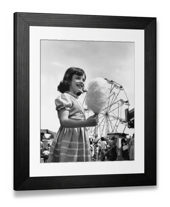 Framed Print : Girl eating cotton-candy at fair