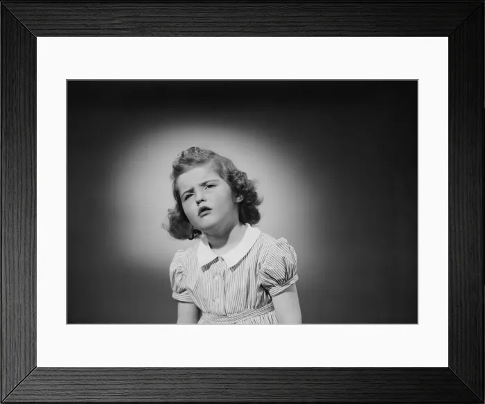 Framed Print : Studio shot of girl (6-7) grimacing Framed Print : Studio shot of girl (6-7) grimacing