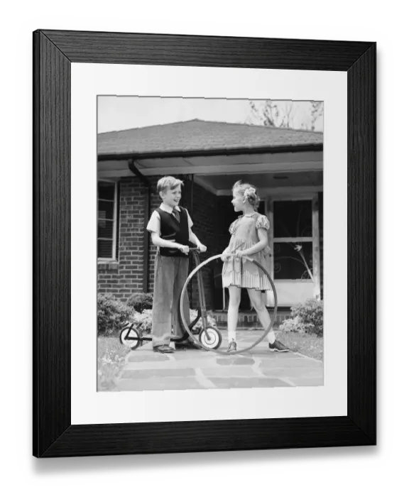 Framed Print : Boy on scooter, girl holding stick and hoop, outdoors Framed Print : Boy on scooter, girl holding stick and hoop, outdoors