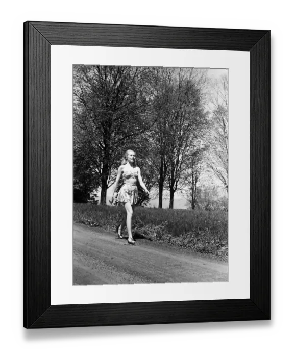 Framed Print : Young woman walking along country road Framed Print : Young woman walking along country road