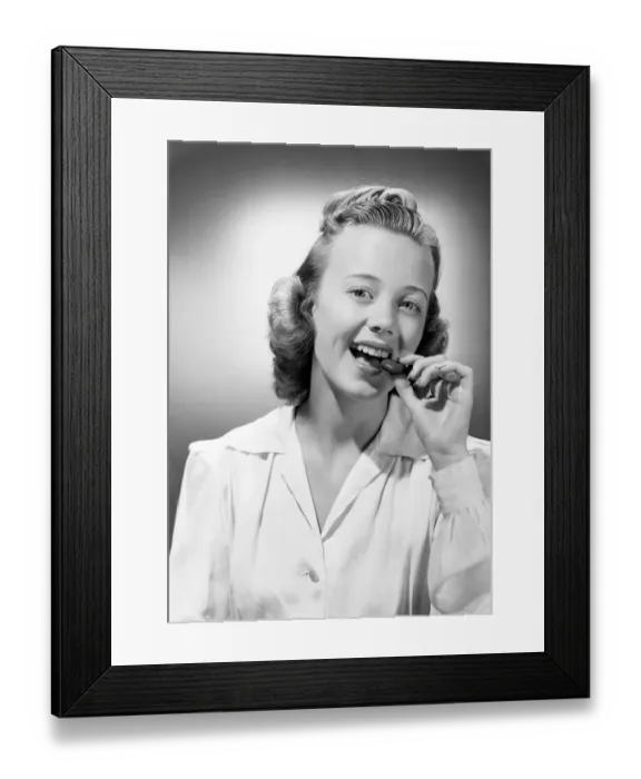 Framed Print : Young woman eating chocolate, portrait Framed Print : Young woman eating chocolate, portrait