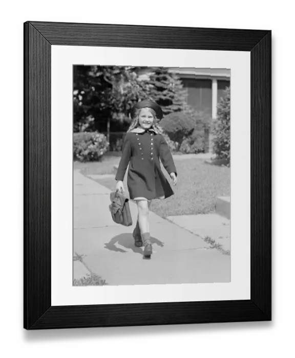 Framed Print : Young girl (8-9) with schoolbag on sidewalk, portrait Framed Print : Young girl (8-9) with schoolbag on sidewalk, portrait