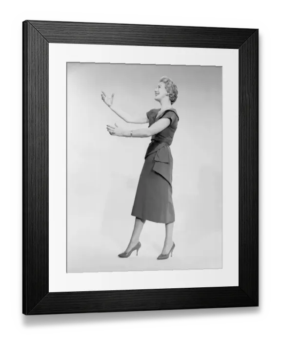 Framed Print : Woman raising arms, studio shot, side view Framed Print : Woman raising arms, studio shot, side view