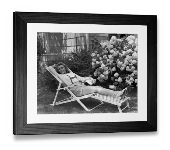 Framed Print : Young woman relaxing in deckchair in garden Framed Print : Young woman relaxing in deckchair in garden