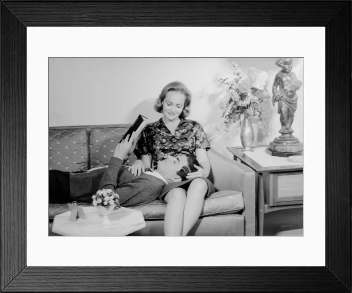 Framed Print : Young couple relaxing on sofa Framed Print : Young couple relaxing on sofa