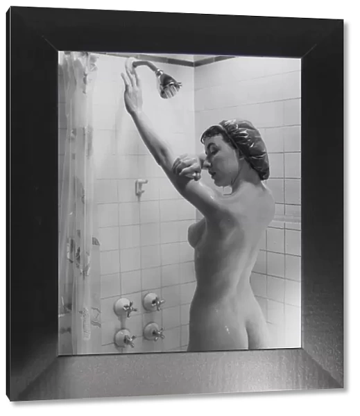 Naked woman showering, rear view