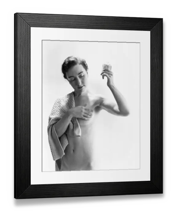 Framed Print : Naked woman covering breast, holding up bottle of perfume Framed Print : Naked woman covering breast, holding up bottle of perfume