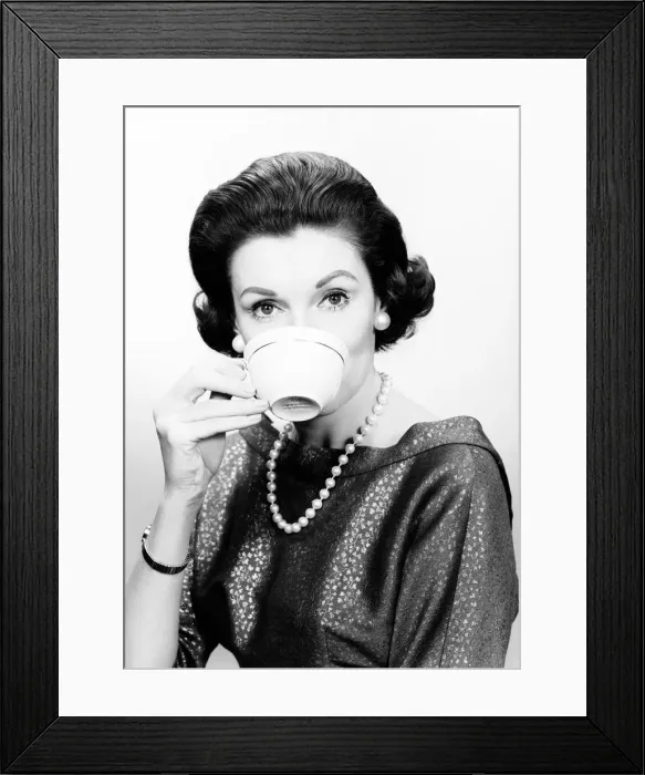Framed Print : Studio portrait of mid adult woman drinking from cup Framed Print : Studio portrait of mid adult woman drinking from cup