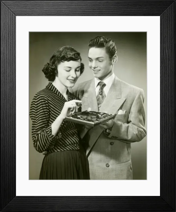 Framed Print : Man offering woman box of chocolates Framed Print : Man offering woman box of chocolates
