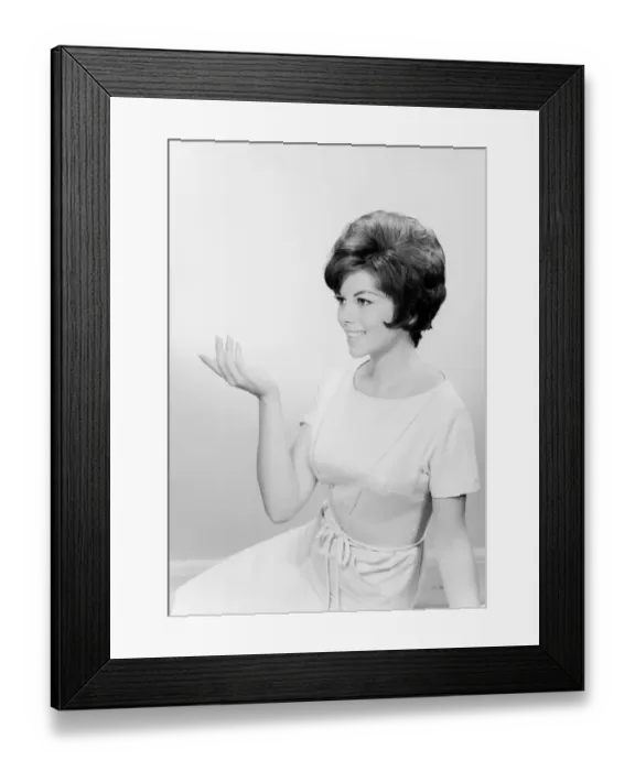Framed Print : Studio shot of young woman with arm raised Framed Print : Studio shot of young woman with arm raised