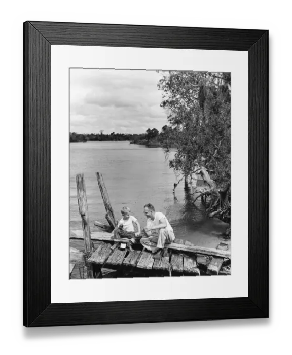Framed Print : Father and son sitting on dock getting ready to fish Framed Print : Father and son sitting on dock getting ready to fish