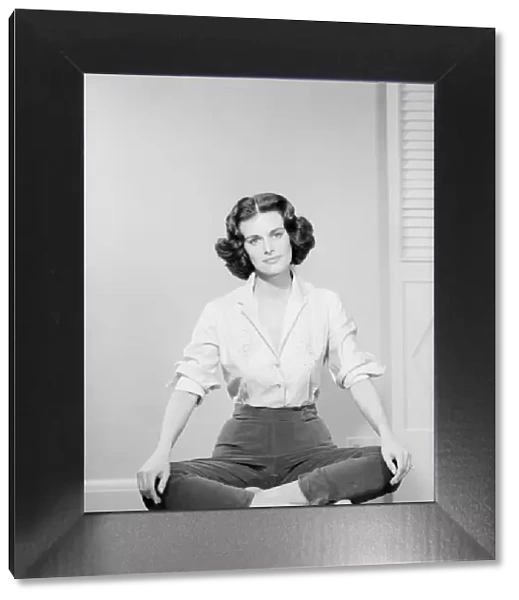 Woman sitting crosslegged on chair, portrait