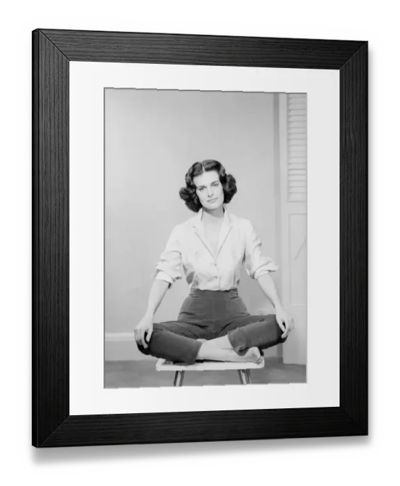 Framed Print : Woman sitting crosslegged on chair, portrait Framed Print : Woman sitting crosslegged on chair, portrait