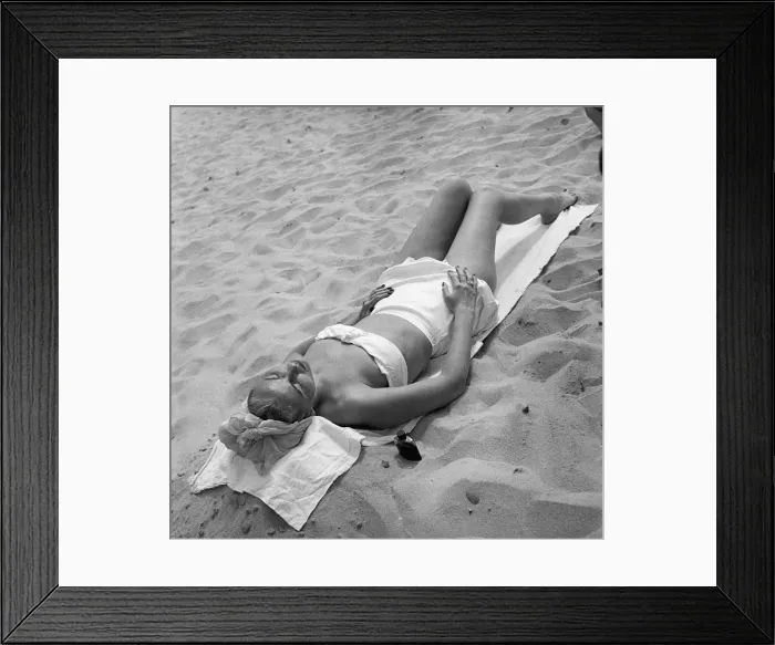 Framed Print : Woman sun tanning on beach, (B&W), elevated view Framed Print : Woman sun tanning on beach, (B&W), elevated view