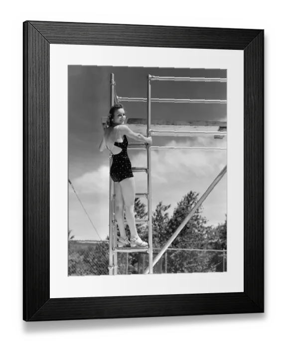 Framed Print : Woman standing on ladder at springboard, (B&W) Framed Print : Woman standing on ladder at springboard, (B&W)